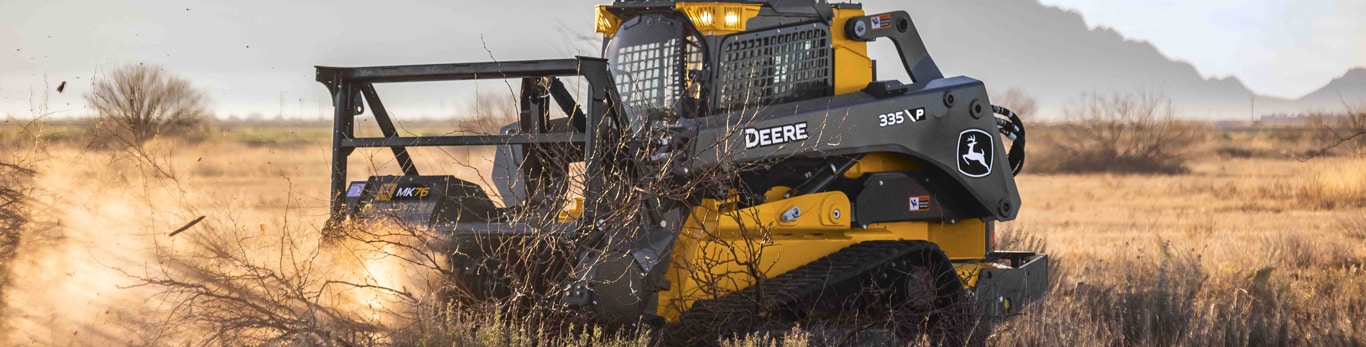  John Deere 335p compact track loader works in a dusty southwestern landscape