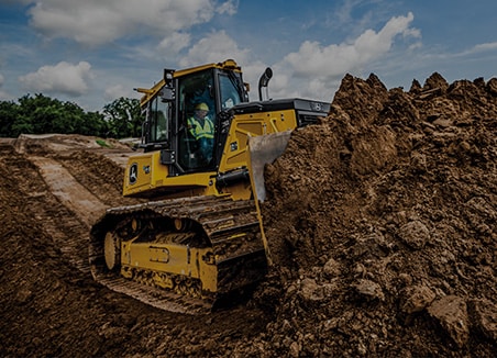 The words “site development” are on top of a John Deere 750L SmartGrade Dozer pushing dirt to prepare the site.  