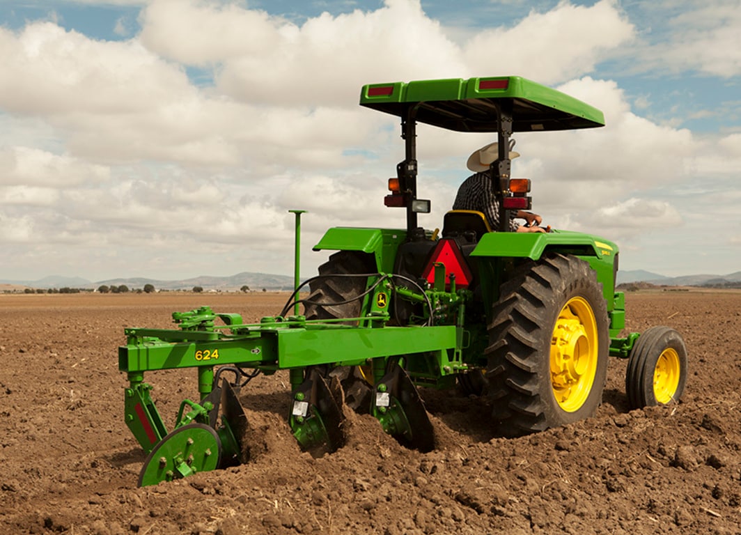 Tractor de John Deere con lo Arado de Discos 624.