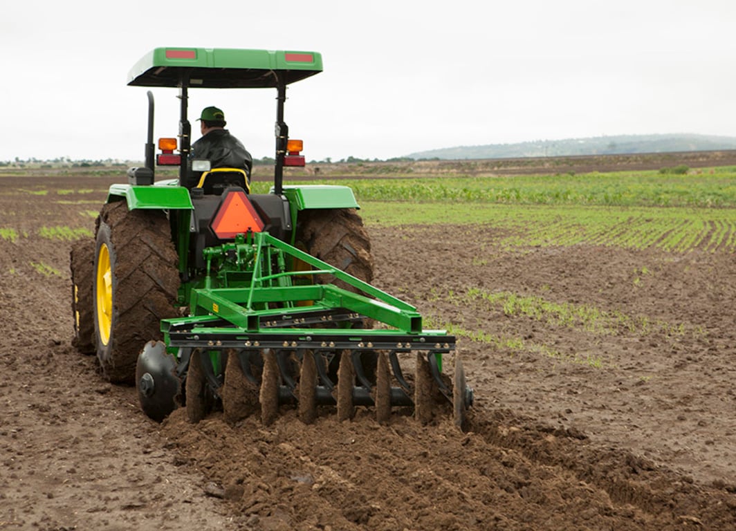 Tractor 5055E con la rastra de John Deere.