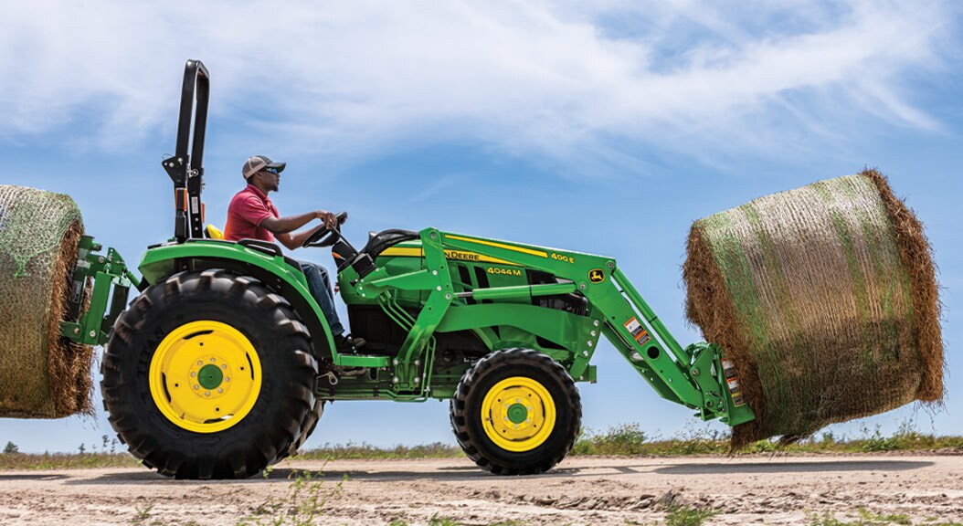 Person transporting bales with a 4044m Compact Utility Tractor
