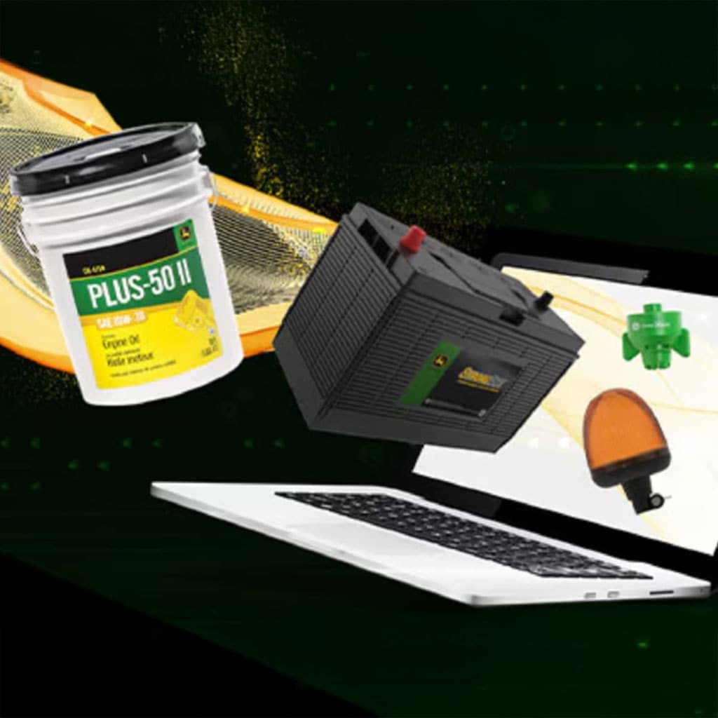 Assorted Deere parts and products, including engine oil, a battery, and equipment components, displayed above a laptop.