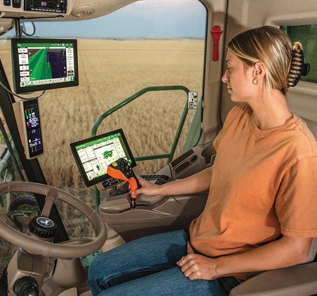 Self‑propelled agricultural sprayer applying liquid across a green field.