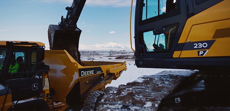 John Deere 230 P-Tier Excavator loads a dump truck