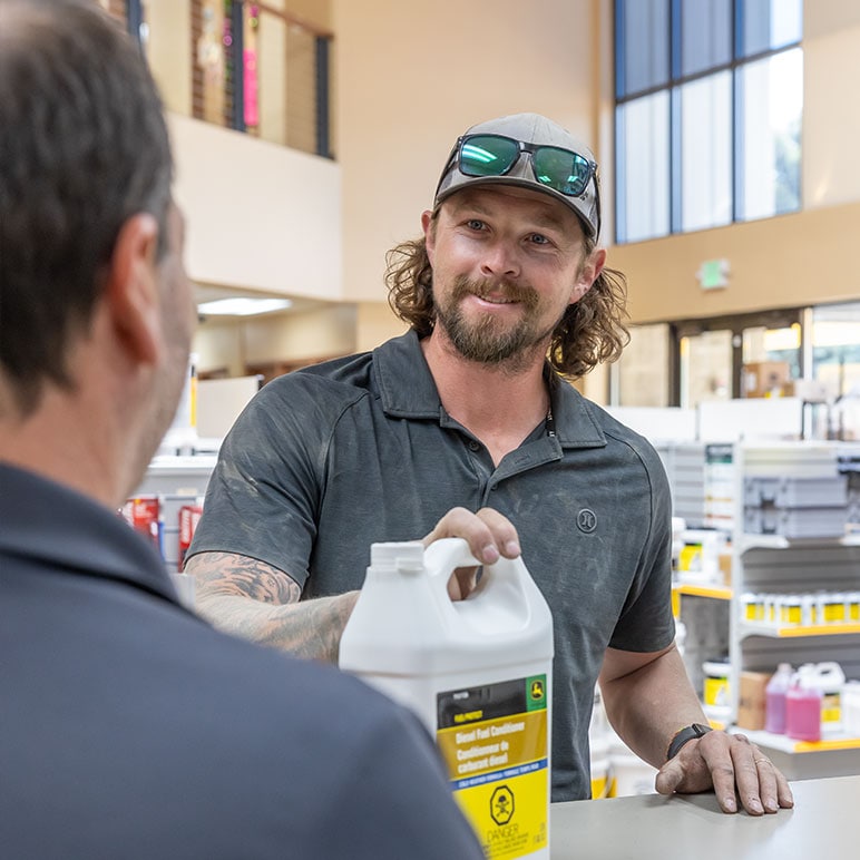 A customer in a dealership talks with a parts counter representative