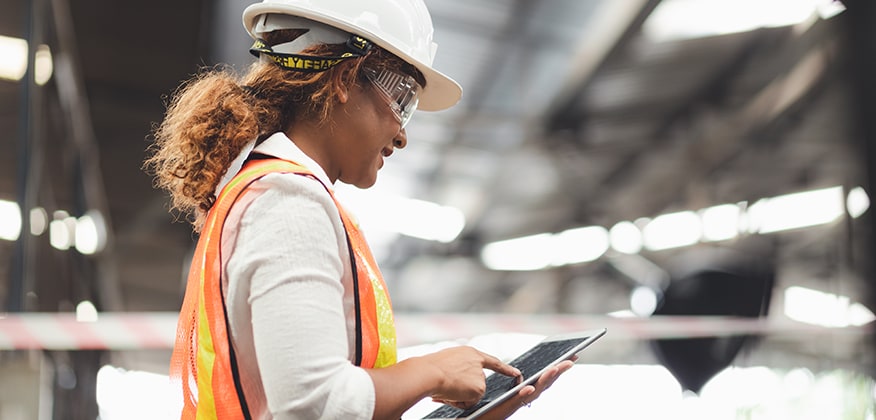 A woman ordering parts from an iPad in a warehouse.