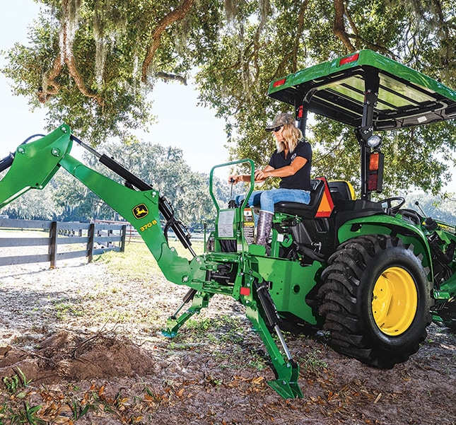 Green compact tractor with backhoe.