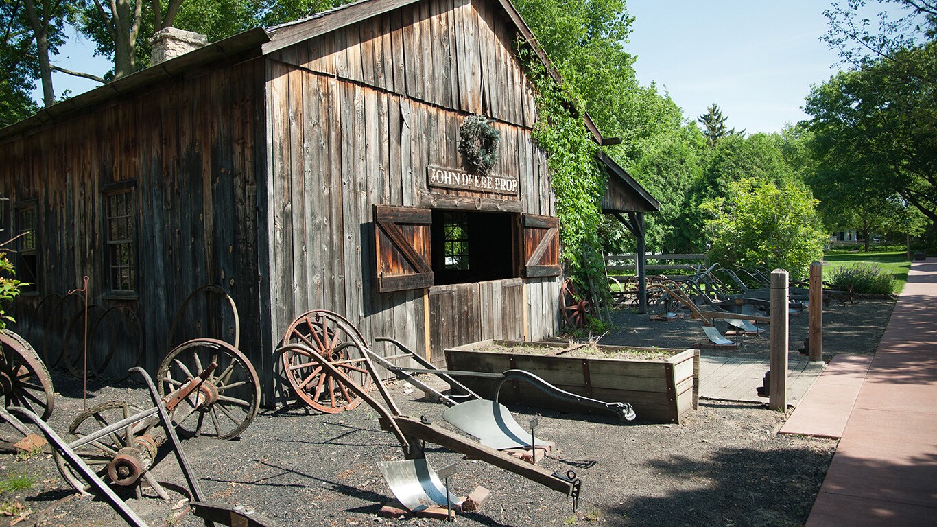 Outside of the original blacksmith shop with some of the John Deere's plows displayed