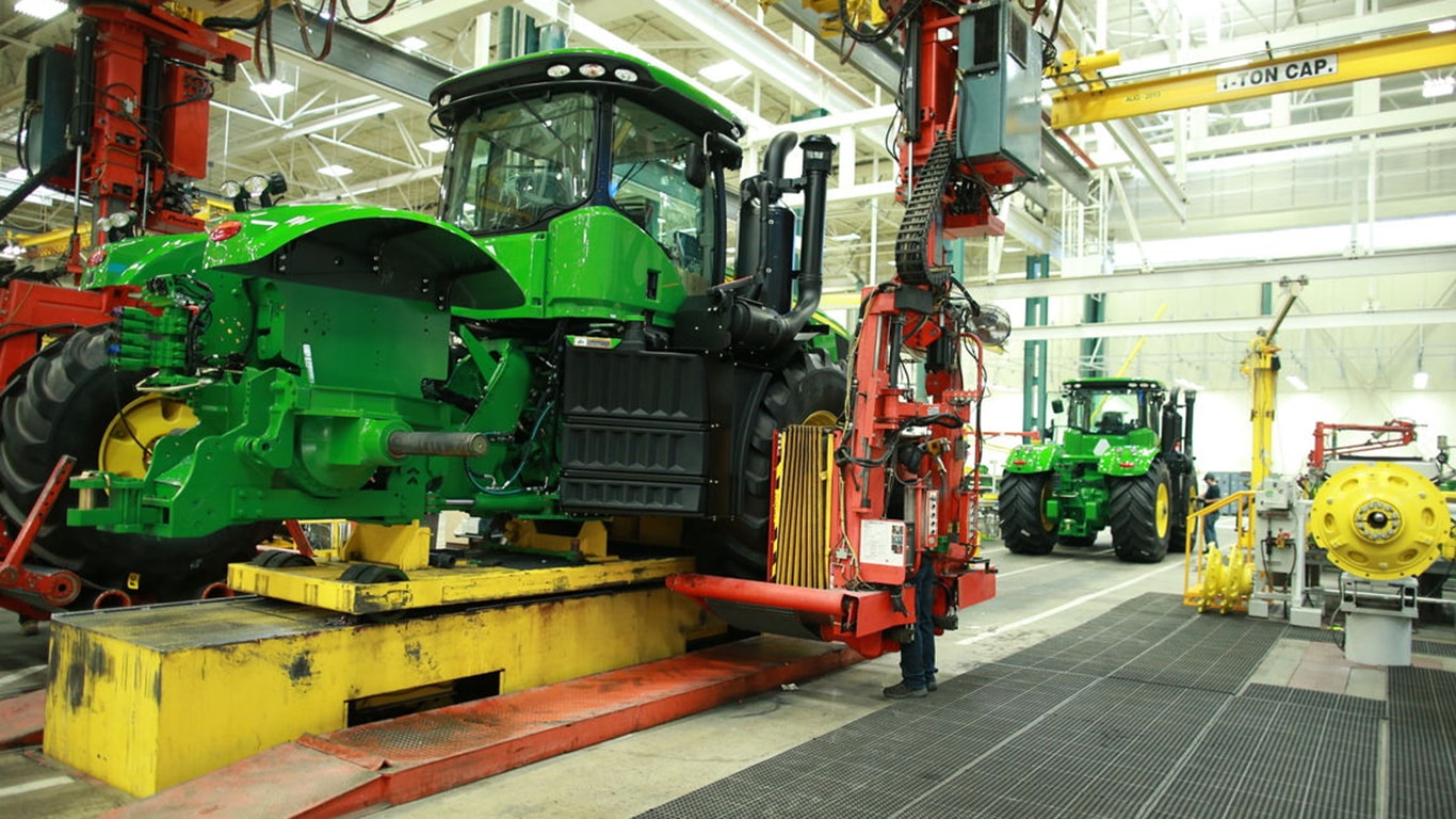 A wheel is put into place as a John Deere tractor moves down the assembly line