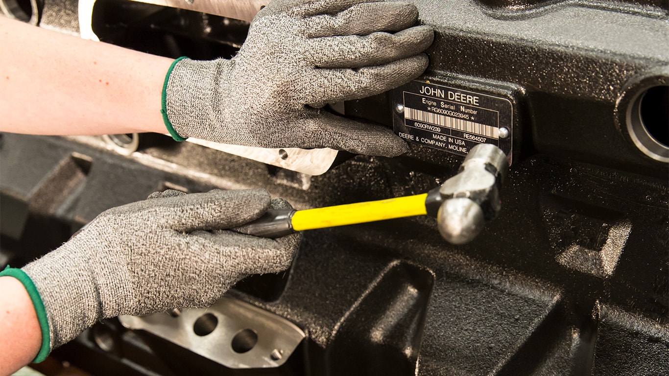 Worker affixing serial number plate to the engine