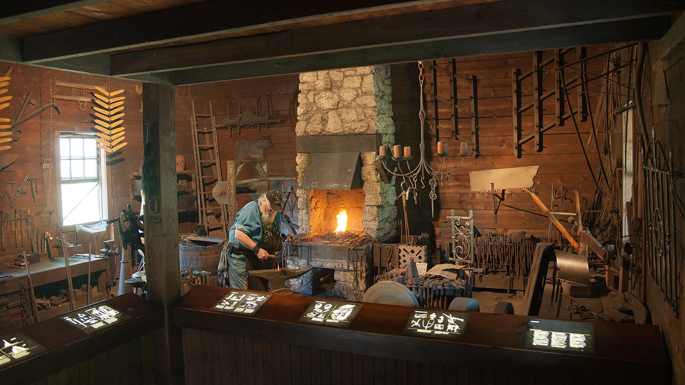 Blacksmith working inside the John Deere blacktop building