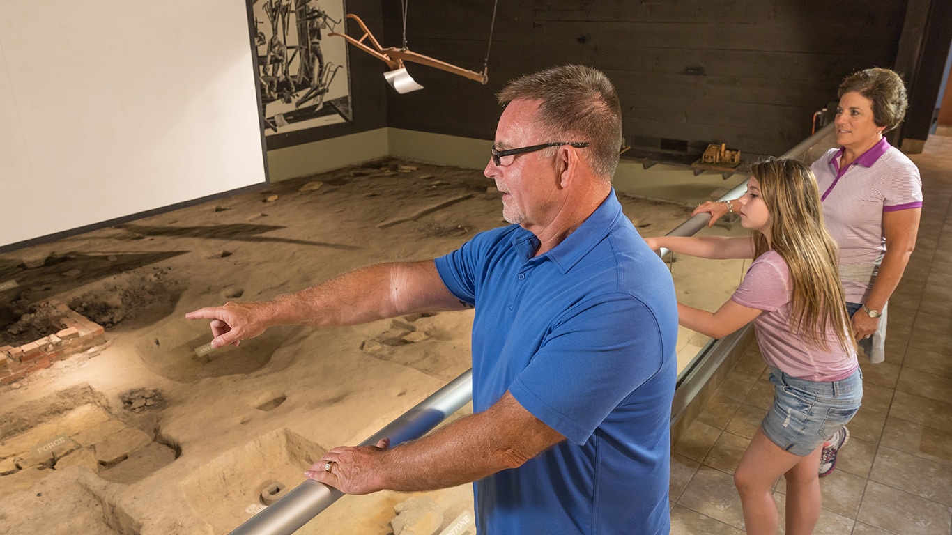 Father, mother and daughter look at an exhibit on the Historic Site 