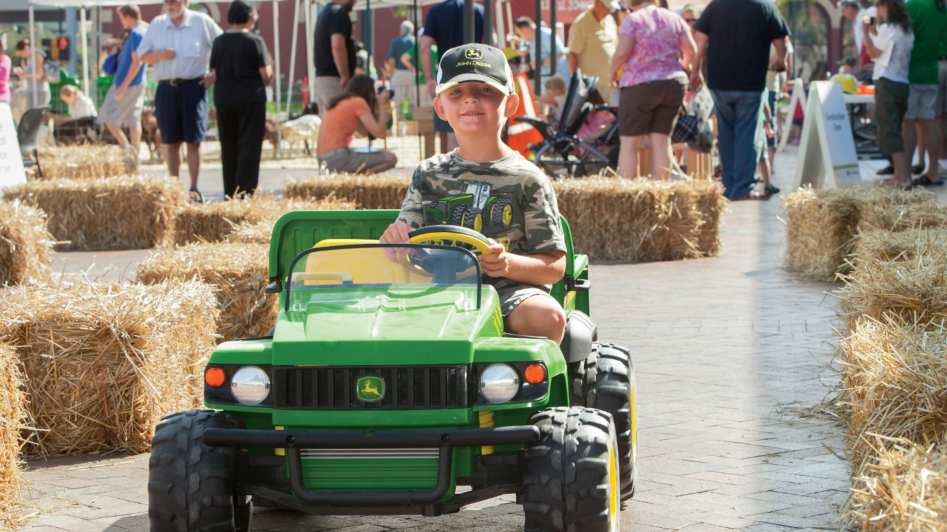 Boy driving a toy John Deere Gator at the Learn and Play Day event