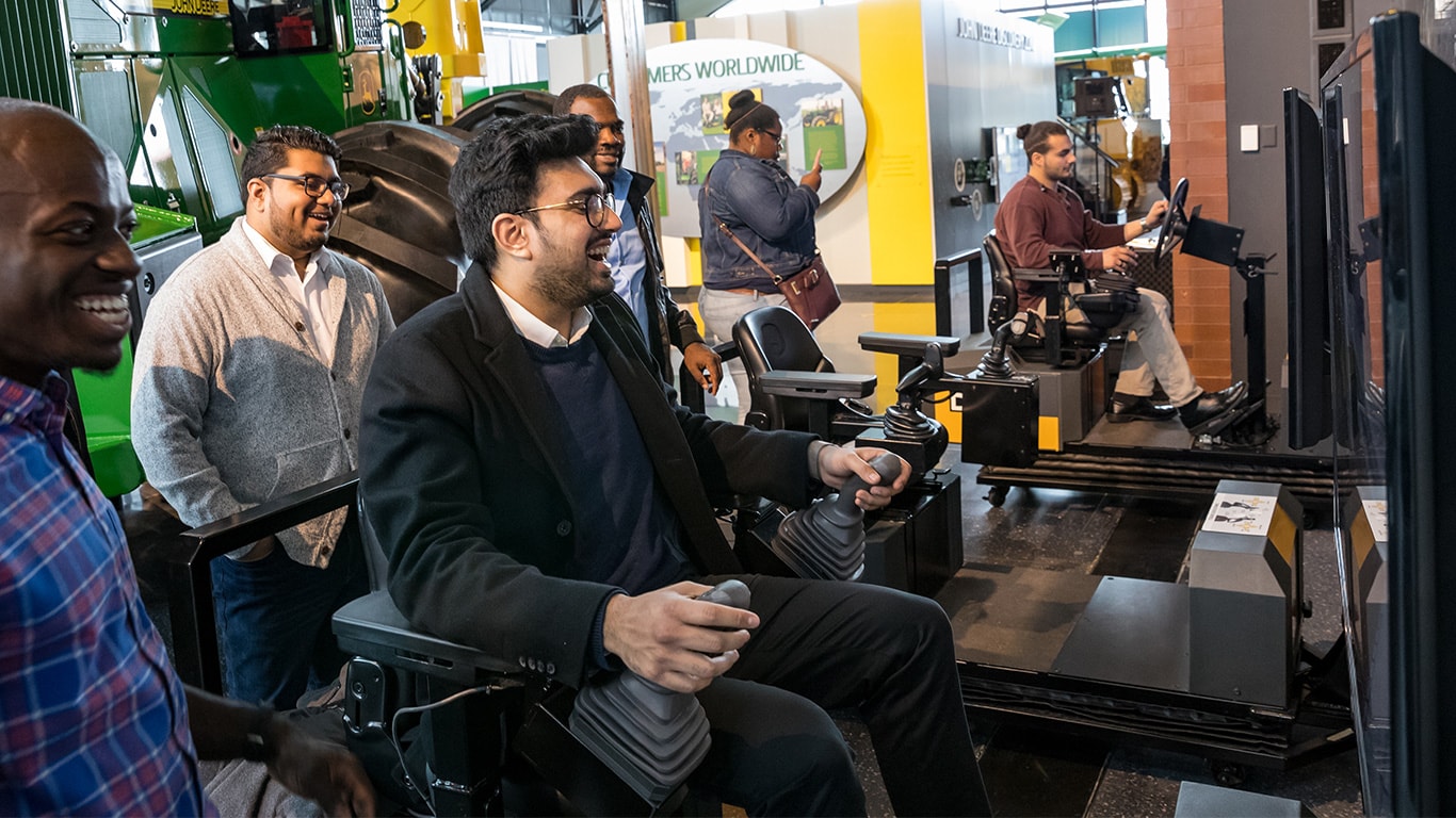 Group of people playing on the construction simulators