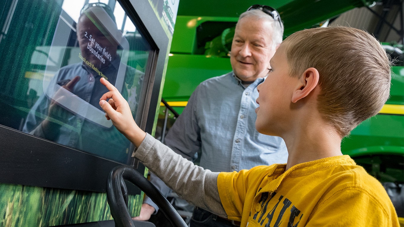  A boy touches video screen as part of an interactive agriculture exhibit