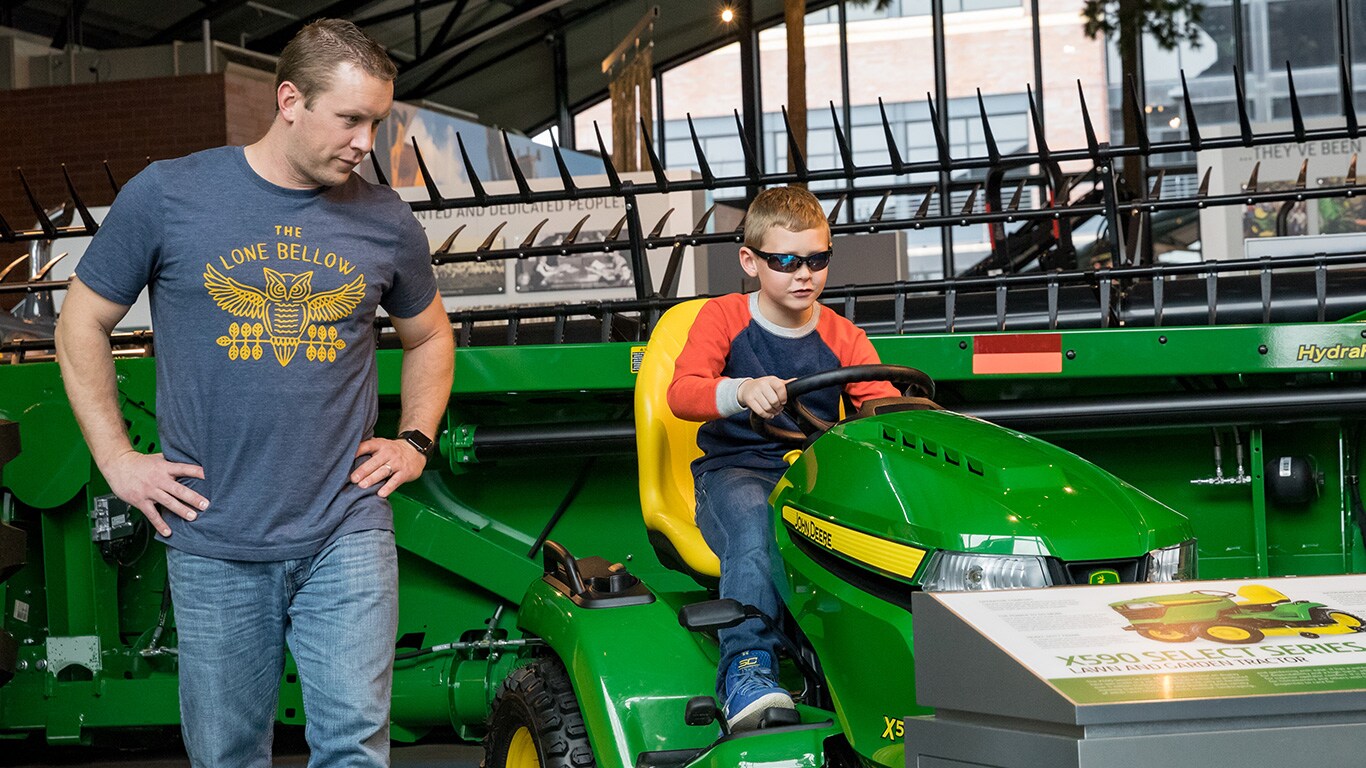 Father and son looking at a John Deere Lawn and Garden Tractor
