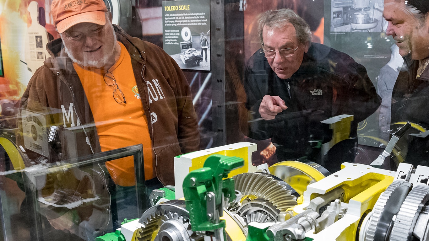 People examining a tractor cutaway on display at the John Deere Tractor and Engine Museum