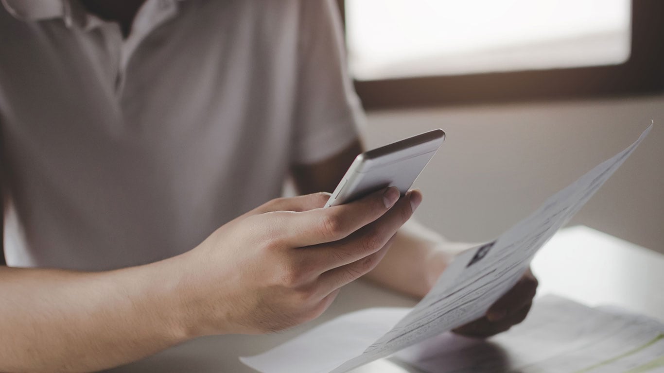 Man using smart phone to pay bill online