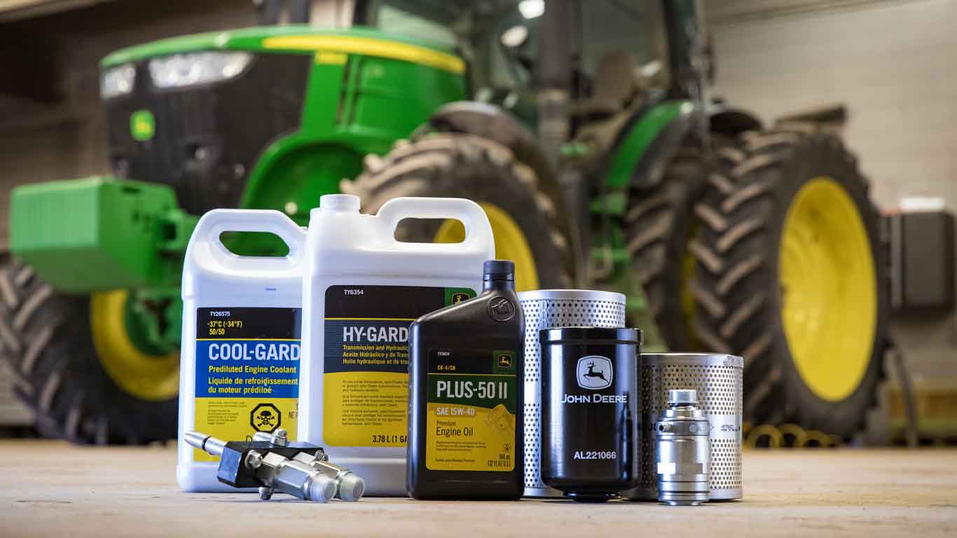 John Deere parts and oil sitting on shop floor