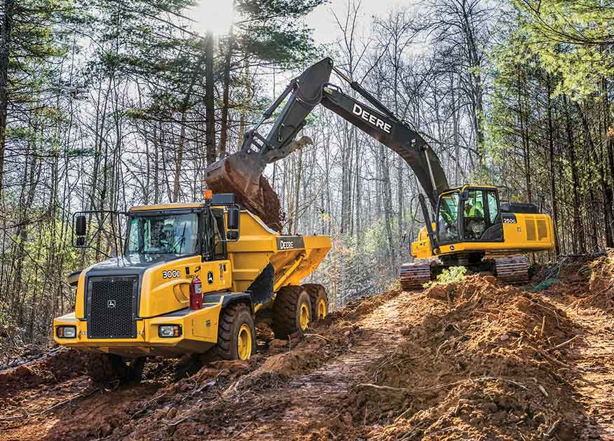 John Deere Construction equipment dumping dirt into a dump truck bed on a work site