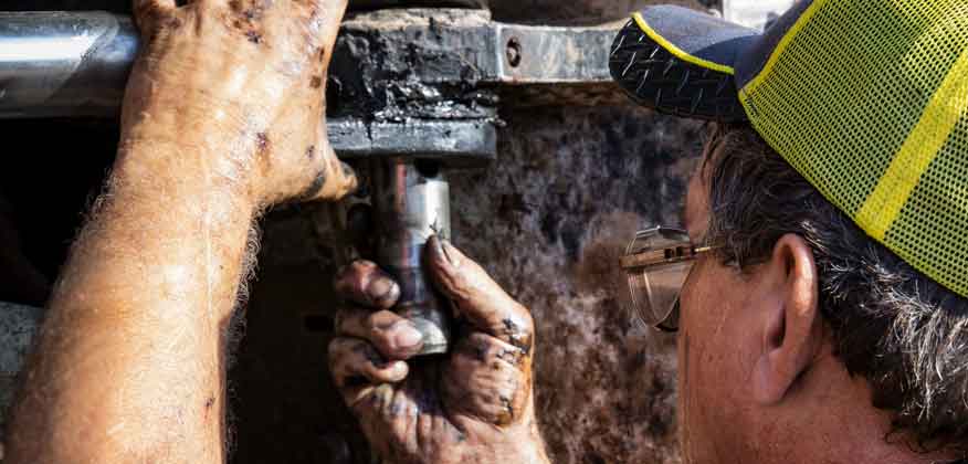 Close up of a man working on John Deere Forestry Equipment