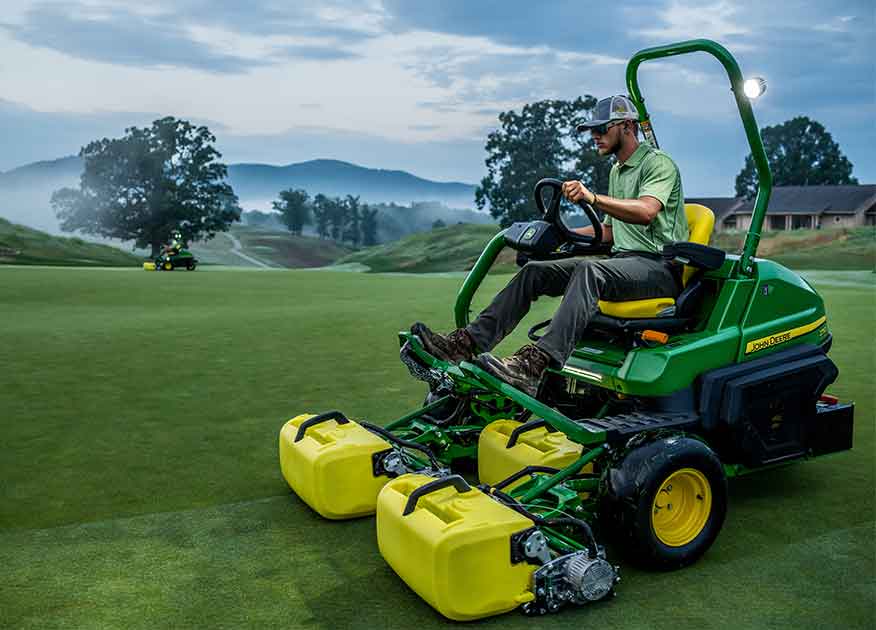 Man operating John Deere Golf equipment on a golf green