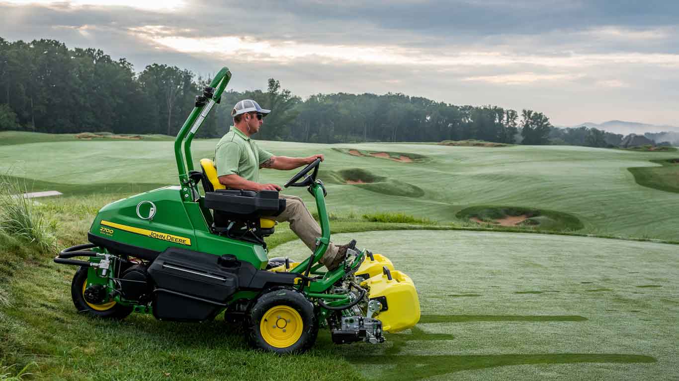 Man operating John Deere golf equipment on a golf course