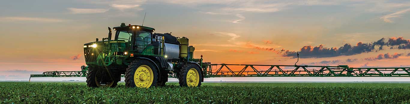 Self propelled sprayer in the field at dusk