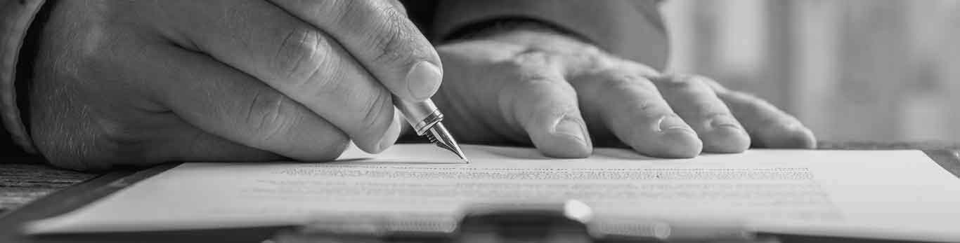 Image of someone signing a document