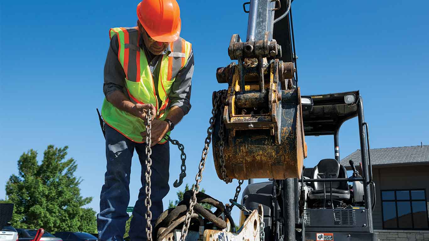Man in construction gear working on a piece of equipment