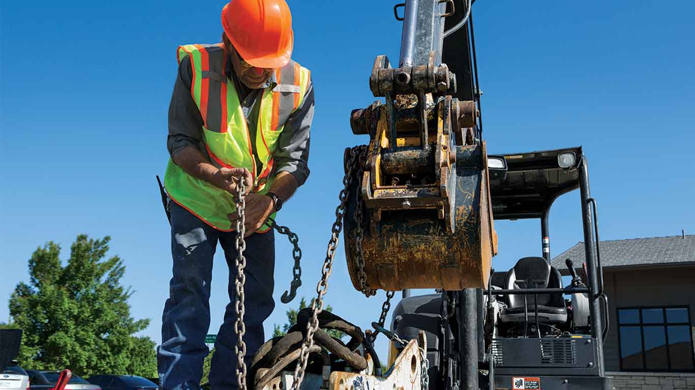 Man in construction gear working on a piece of equipment