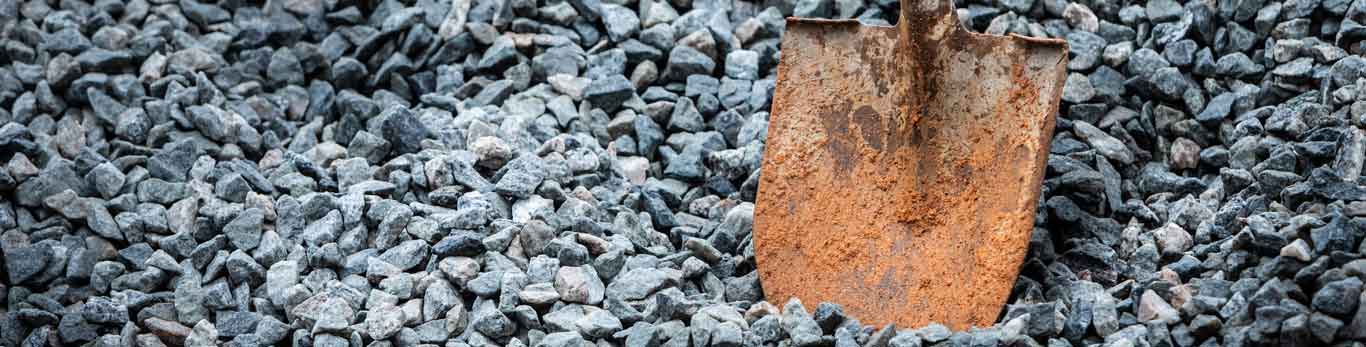 Close up of a dirt shovel standing in a rock pile