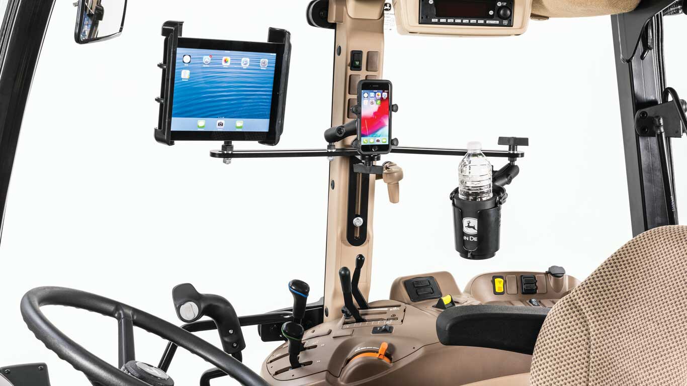 Image of the inside of a tractor cab showcasing tablet, phone and cup holders.
