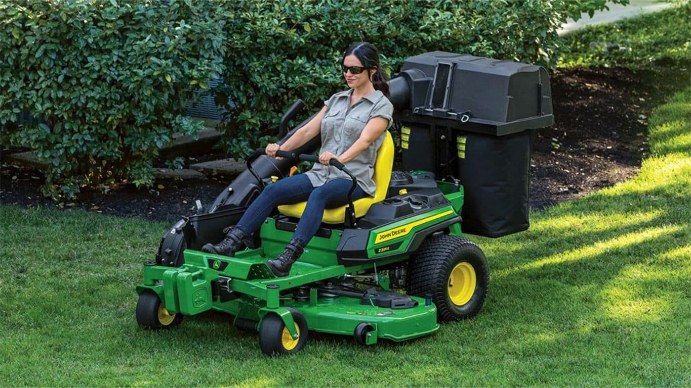 Person mowing lawn using a Z325E with a bagger attached