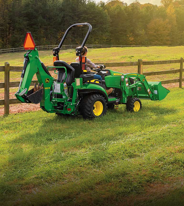 Woman driving a 3E Series Compact Tractor in a field.