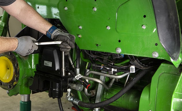 Person installing AutoTrac&trade; Controller 300 on a tractor