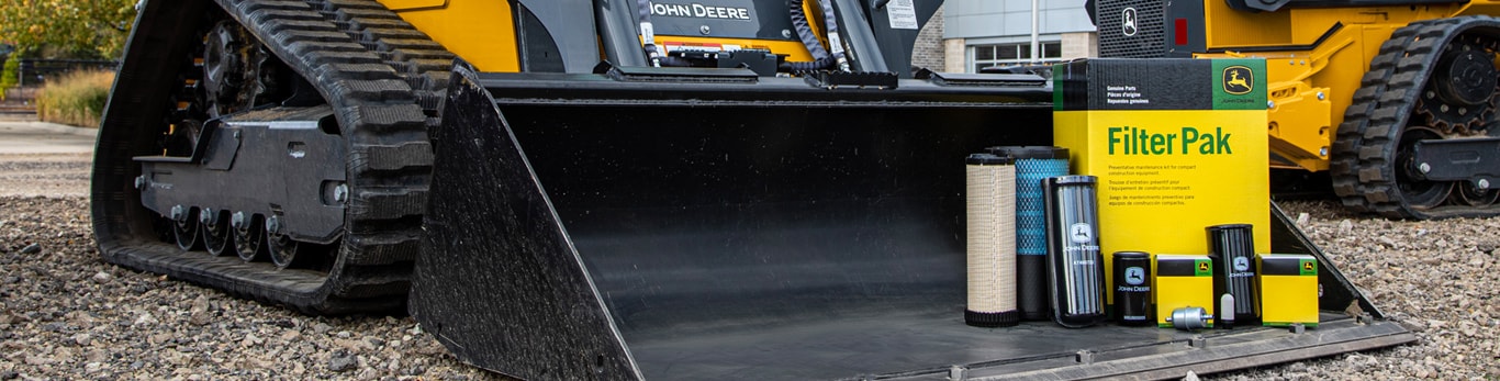 Filters and oil container sitting on the blade of a compact track loader