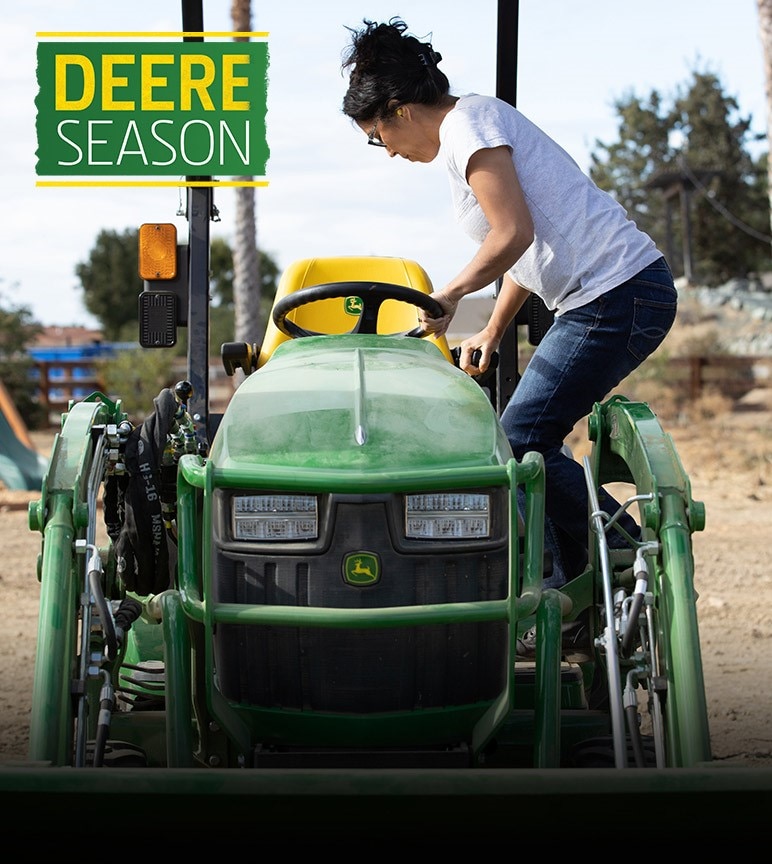 Woman climbing onto a 1025r compact utility tractor