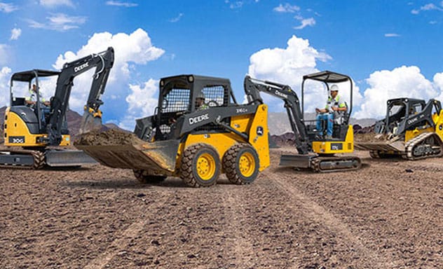 Skid steers, mini excavators and a compact track loader line up on a jobsite with a blue sky background