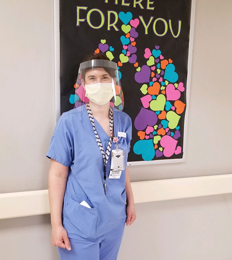 Healthcare working wearing a face shield provided by John Deere.