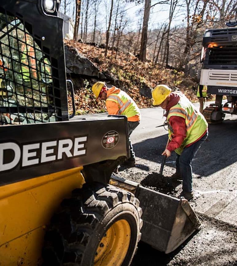 Pepe Fonseca operates a John Deere 3247G Skid Steer as James Garron and Victor Gomez provide assistance on a paving project. Epifanio Carales controls the Wirtgen Cold Milling Machines behind them.