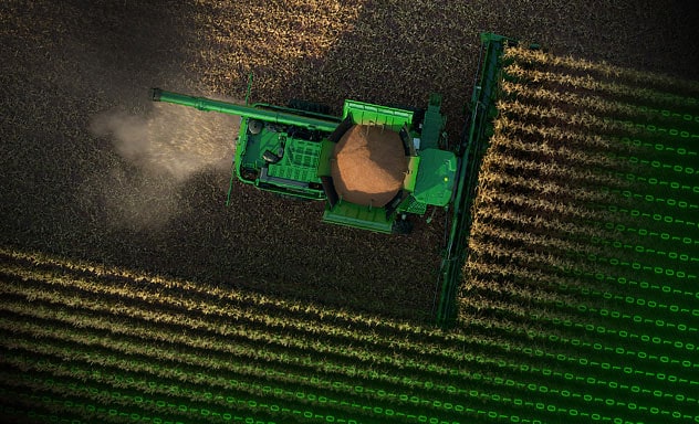 Arial view of combine harvesting in a corn field.
