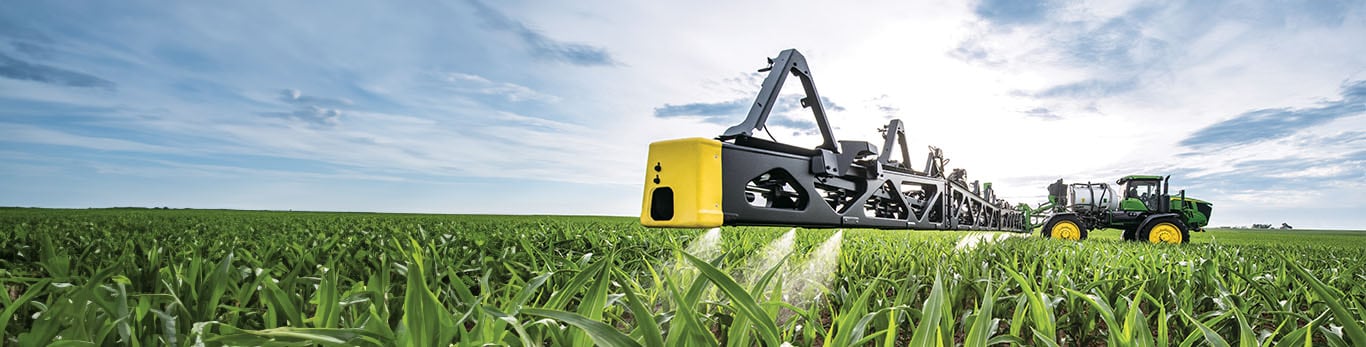A John Deere Sprayer target spraying weeds in a field.