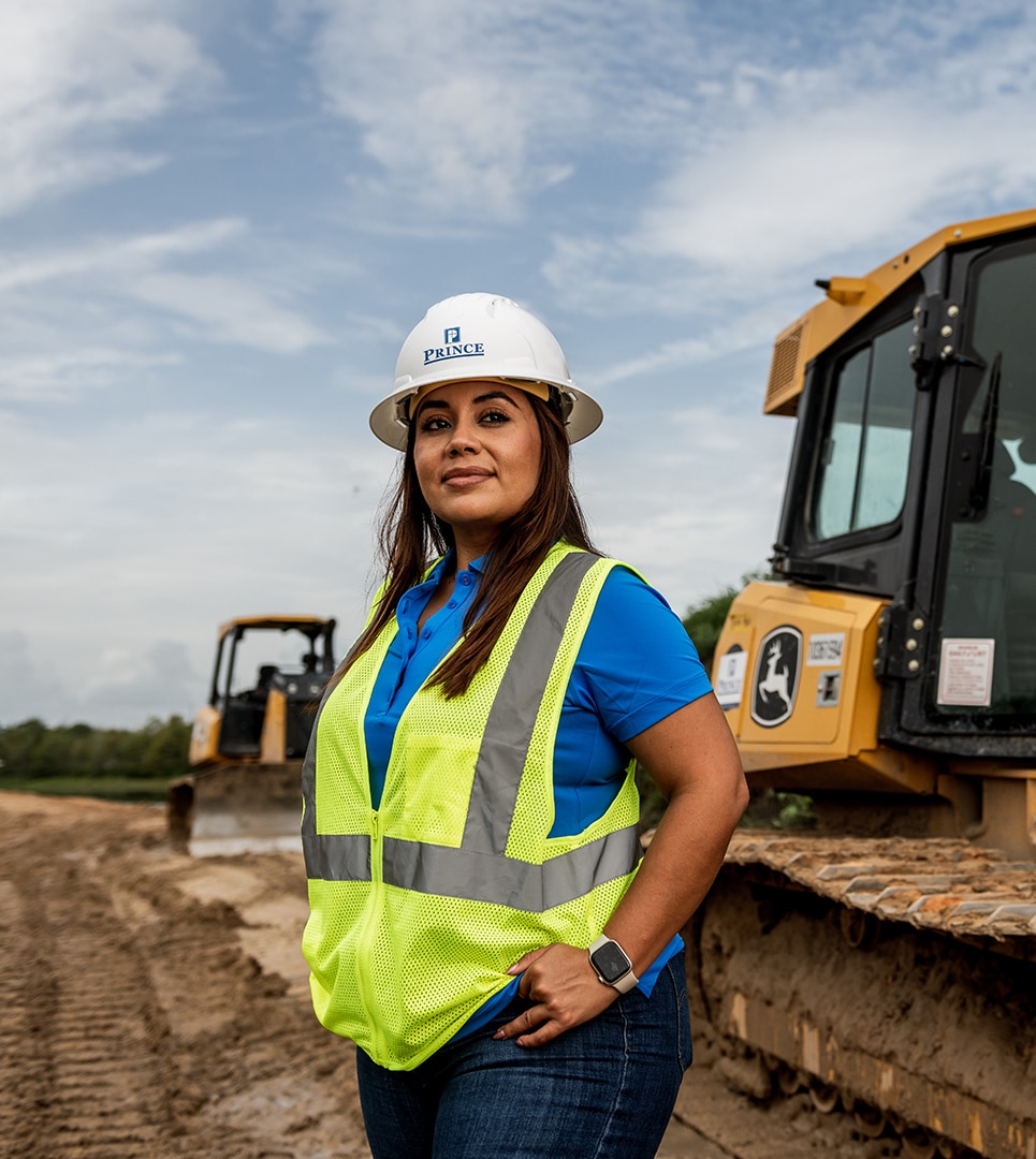 A female operator stands in front of her 650K Crawler Dozer