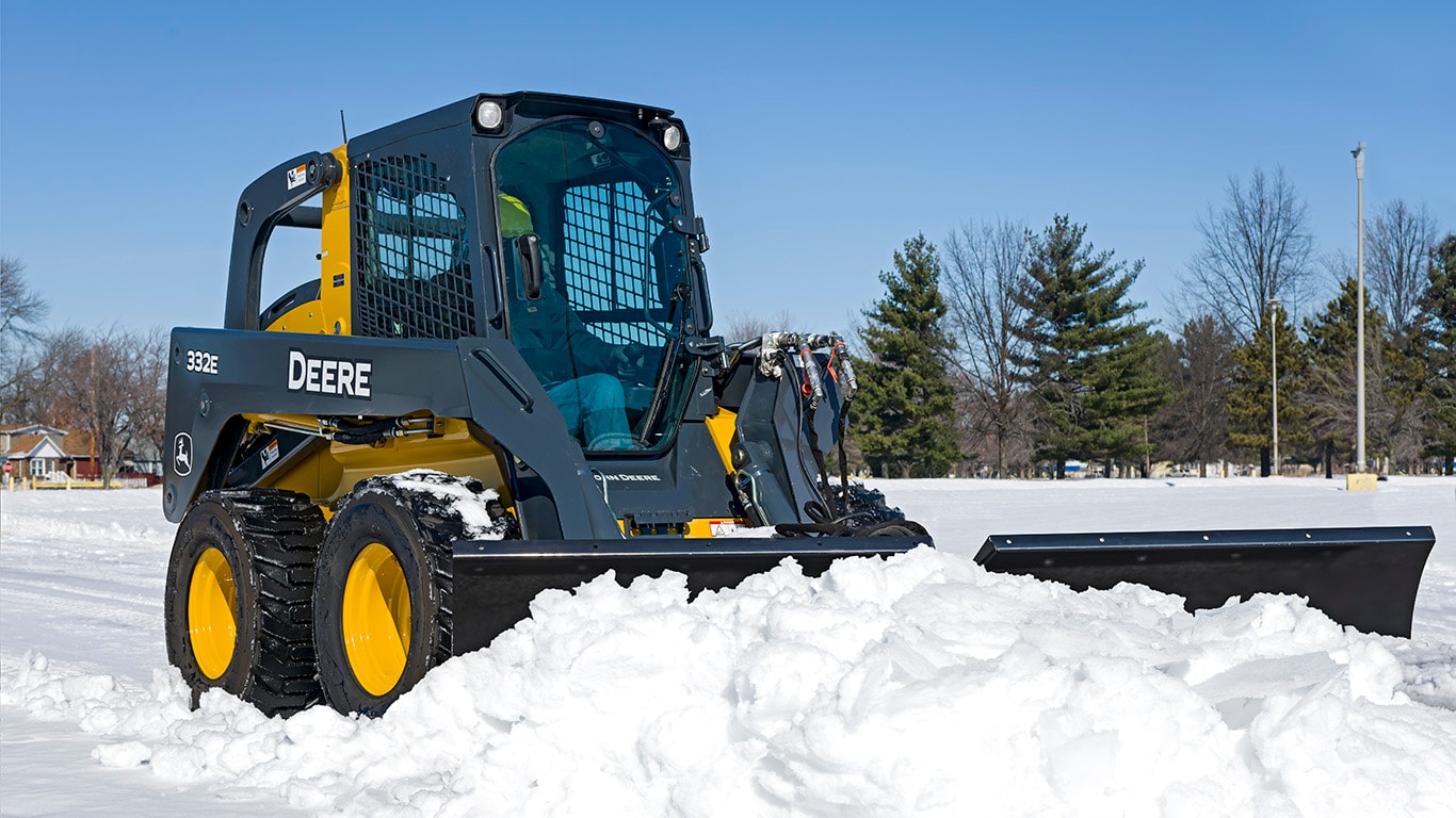 Carretilla Elevadora 332E con un accesorio de Cuchilla en V para Nieve.