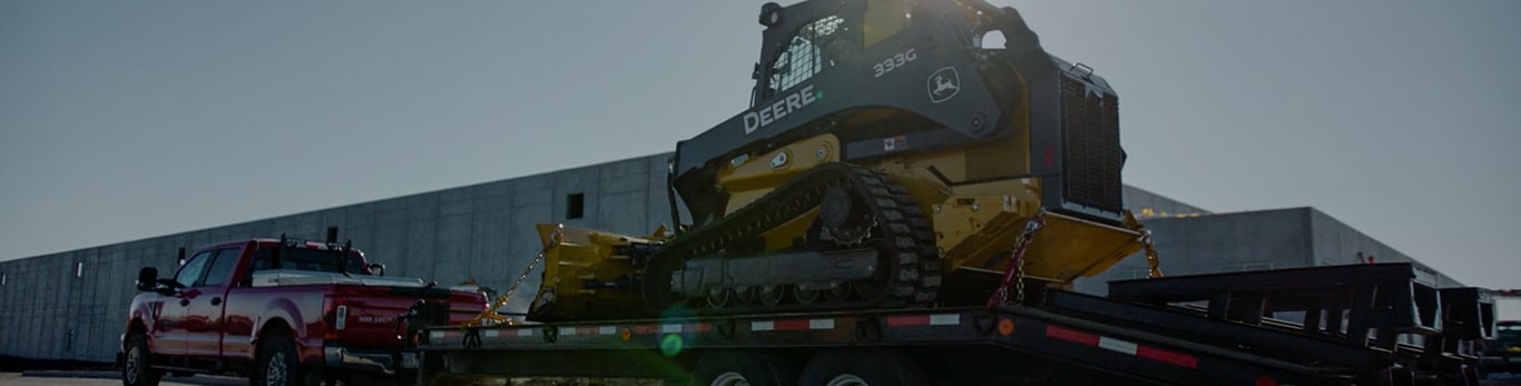 333G SmartGrade Compact Track Loader is hauled on a trailer by a pickup truck