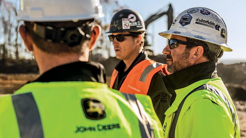 Executives from a construction company are discussing plans for the future with their John Deere dealership representative.