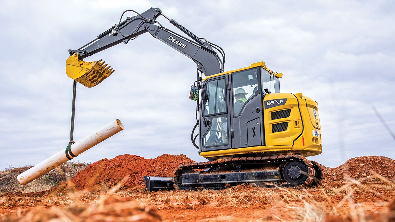 85 P-Tier excavator lifting pipe on job site.