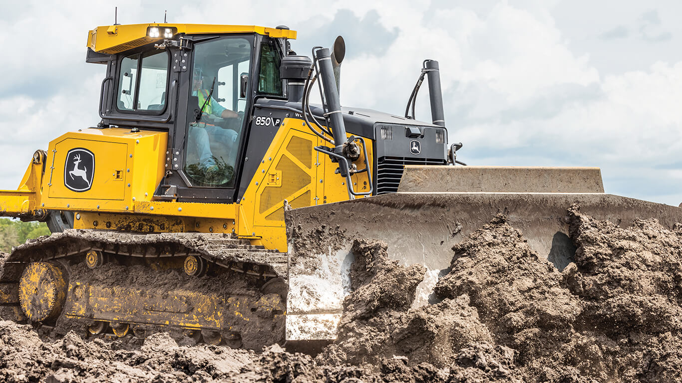 850 P-Tier dozer pushing dirt with blade on job site.