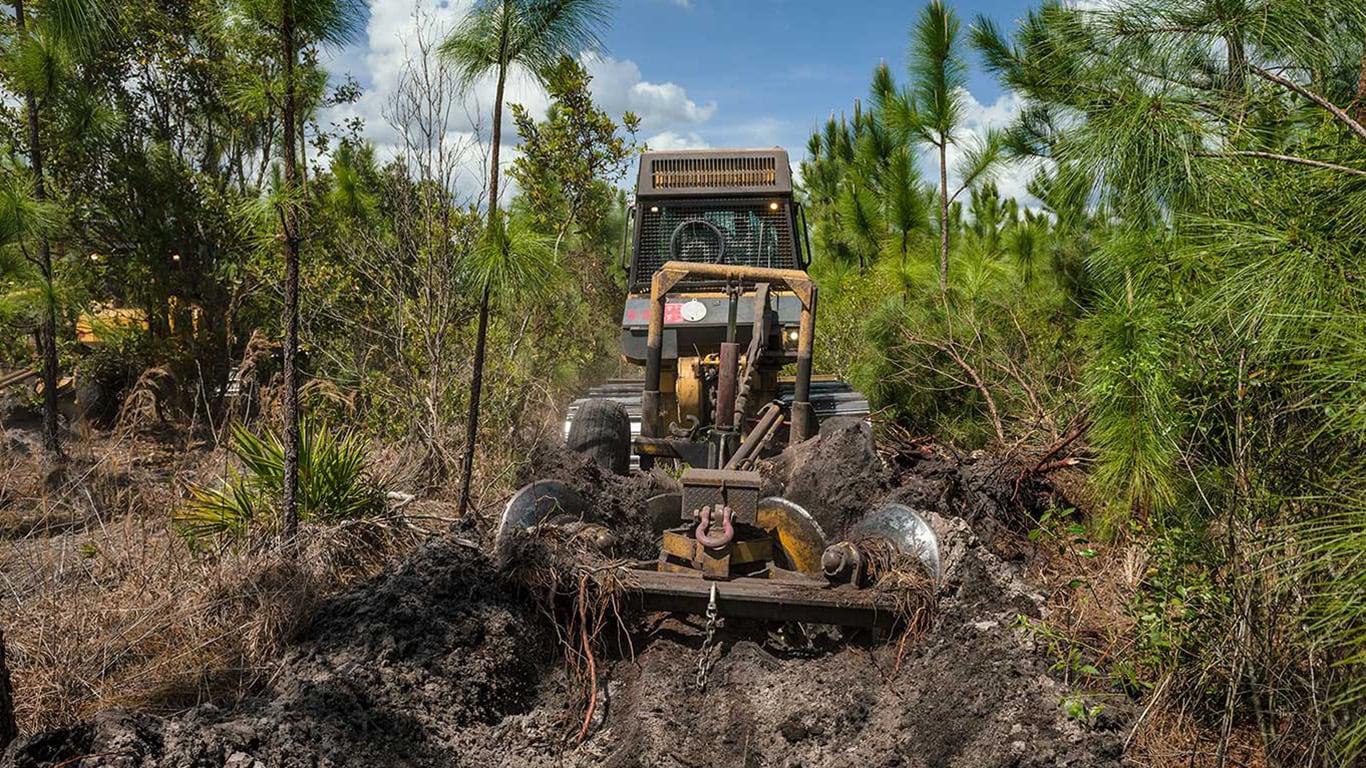 image of John Deere construction skid steer in forest